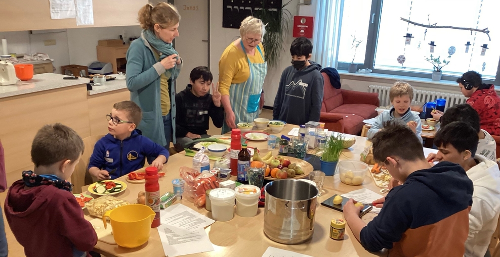mehrer Schüler beim schneiden von Obst und Gemüse